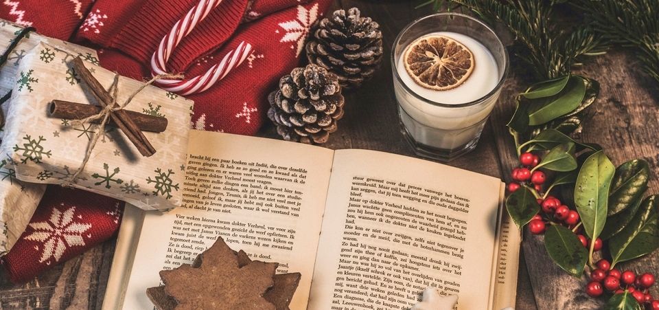 Weihnachtsdekoration mit Buch, Kerze, Geschenken und Plätzchen
